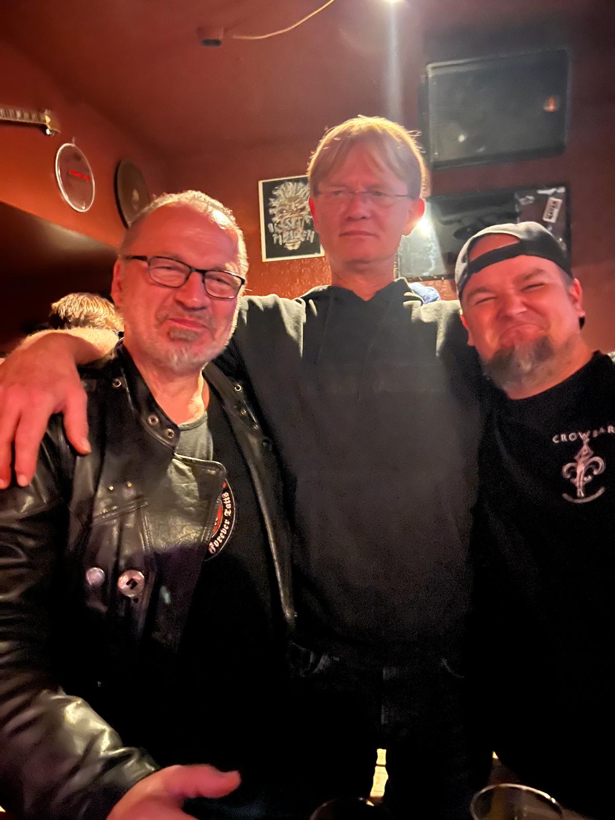 Bandmitglieder spielen gemeinsam Gitarre und Bass im Proberaum